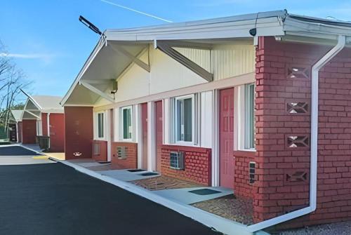 a red brick building with a metal overhang on it at Travelodge by Wyndham Bay Shore Long Island in Bay Shore