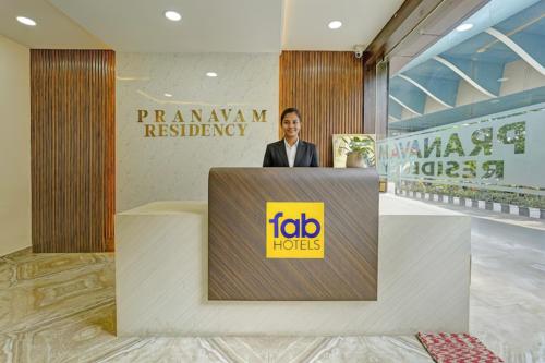 a woman is standing behind a podium at a firmmarkagency headquarters at FabHotel Pranavam Residency in Tirupati