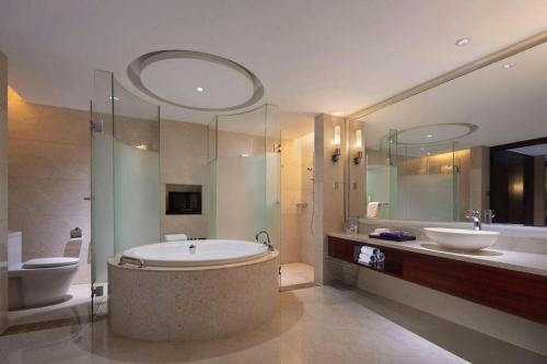 um banheiro com banheira, vaso sanitário e pia em White Swan Hotel ChangSha em Changsha