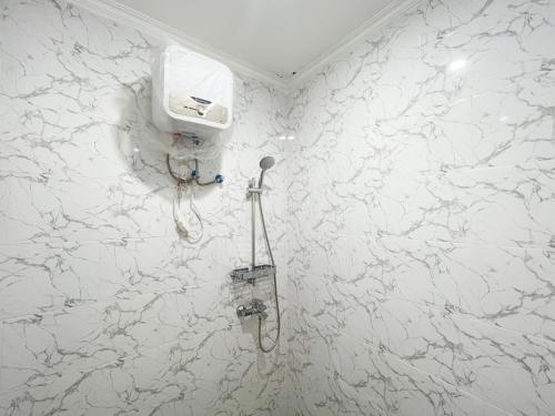 a bathroom with a white marble wall at The Lavana Kubu Be Long Sanur in Sanur