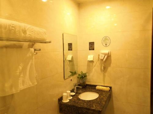 un baño con lavabo y espejo en GreenTree Inn Beijing Daxing District Yufa Town New Airport Express Hotel, en Beijing