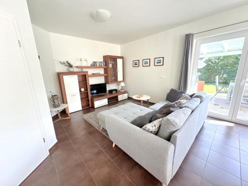 un soggiorno con un divano e una TV di Ferienhaus Sanddorn am Hochzeitsberg a Breege