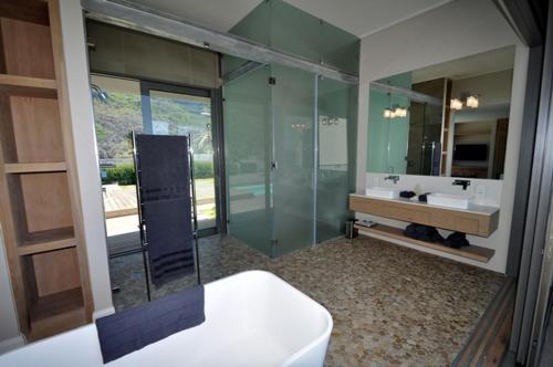 a bathroom with a glass shower and a sink at Cliffhanger Estate in Keurboomstrand