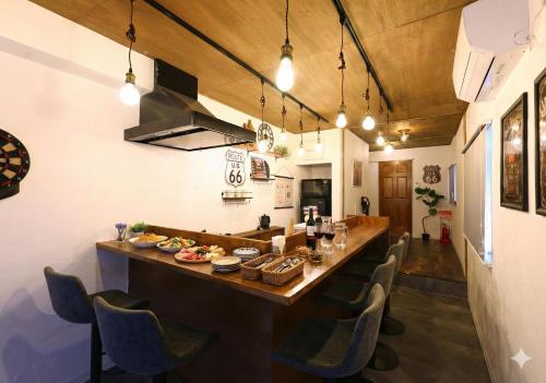 a large wooden bar in a room with chairs at 和氣会々都立家政 Wakiaiai Toritsukasei in Tokyo