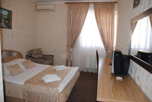 a hotel room with a bed and a television at Globus Hotel in Ternopilʼ