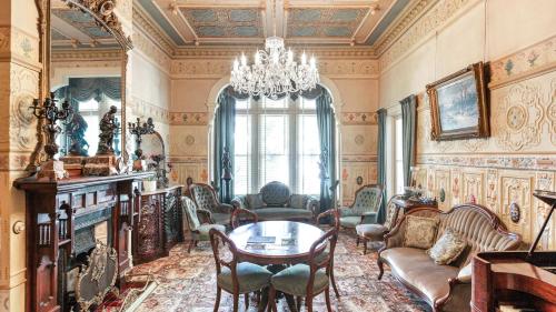 a living room with a chandelier and a table and chairs at Mt Eden Victorian Villa in Auckland