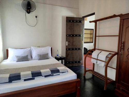 a bedroom with a bed and a chair in it at Step Inn Ahangama in Ahangama