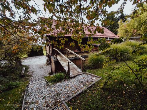 a house with a wooden bridge in a yard at Hay barn unique experience Visole in Slovenska Bistrica