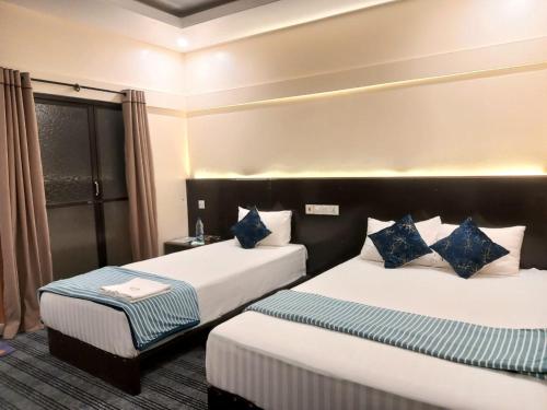 斯里曼加尔乌帕齐拉Jolpoddo Retreat的酒店客房 - 带两张带蓝色枕头的床