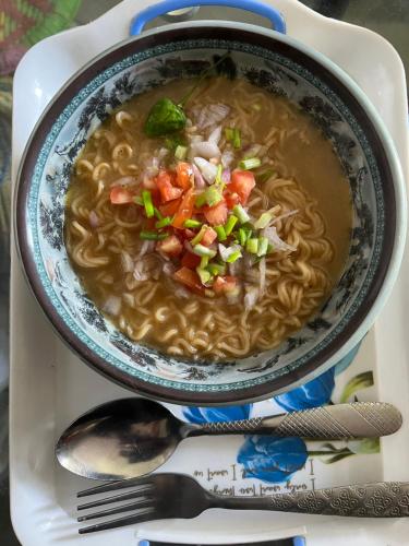 eine Schüssel Suppe auf einem Teller mit einem Löffel in der Unterkunft Gangamaya Homestay Darjeeling in Darjeeling