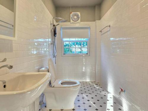 Ban Thamสะพรั่งกลางขุนเขา - Saprung on the mountain的带马桶和水槽的白色浴室