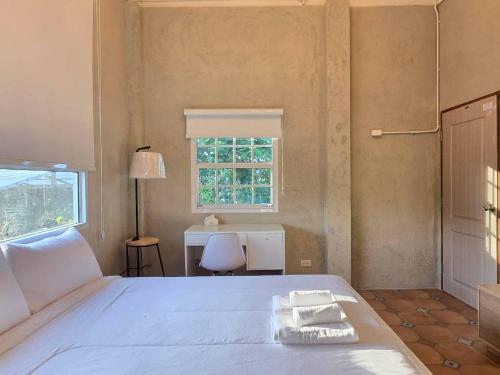 Ban Thamสะพรั่งกลางขุนเขา - Saprung on the mountain的卧室里有一张床，床上放着两条毛巾。