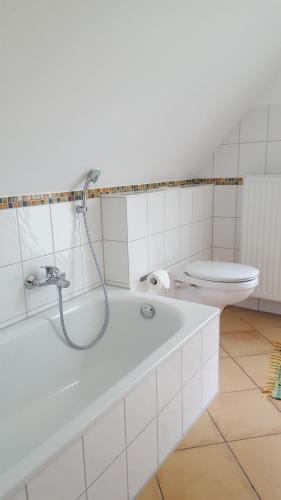 a white bathroom with a shower and a toilet at FeWo Machedanz mit Balkon Timmendorfer Strand OT Niendorf in Timmendorfer Strand