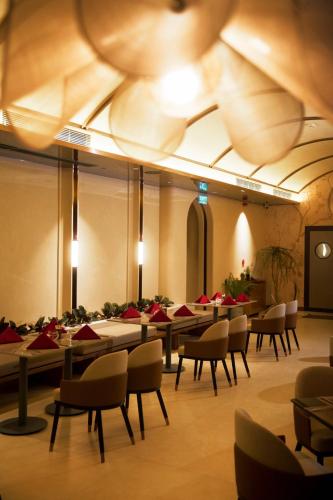 Un comedor con mesas y sillas y un techo en The IRIS SIGNATURE HOTEL AND SPA, en Can Tho