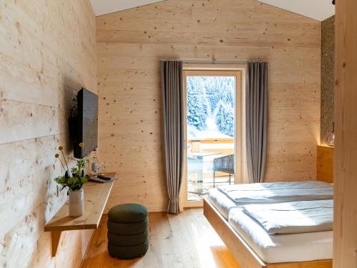 a bedroom with a bed and a window at Berghotel Wald&Wiesn in Balderschwang
