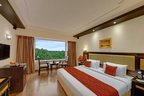 Una habitación de hotel con una cama grande y una ventana. en Hotel Tamilnadu Trichy Unit 2 - Formerly SRM, en Tiruchirappalli