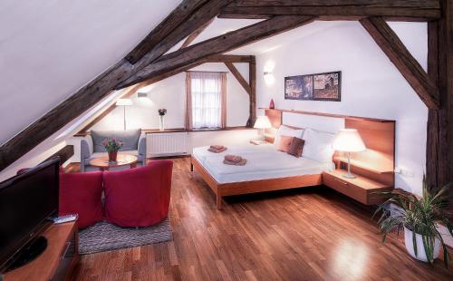 ein Schlafzimmer mit einem Bett und ein Wohnzimmer in der Unterkunft Penzion Baltazar Mikulov in Mikulov