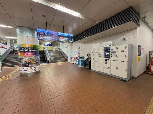 an empty aisle of a store with refrigerators and stairs at Elle Maison大森 102 in Tokyo