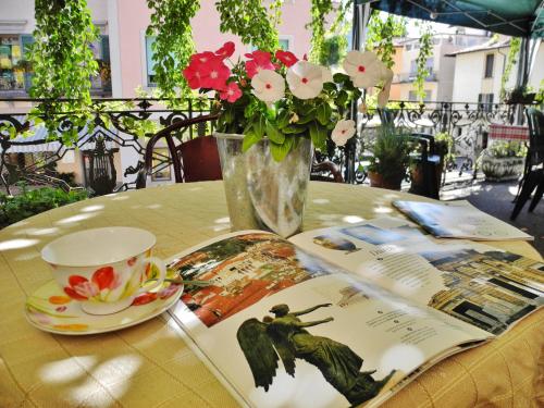 uma mesa com um vaso de flores e uma revista em B&B La Veranda - Iseo em Iseo