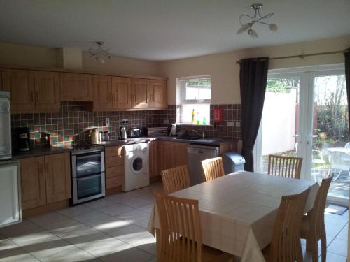 uma cozinha com uma mesa, um fogão e um lavatório em 15 Sheen View Kenmare Co Kerry em Kenmare
