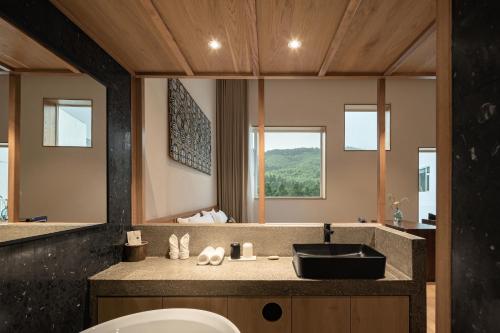 ein Badezimmer mit Waschbecken und Spiegel in der Unterkunft 西坡劳岭良室民宿 in Wukang