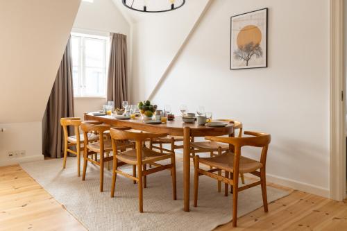 a dining room with a wooden table and chairs at Light-Filled 5BR Home Near Tivoli & Strøget for 12 in Copenhagen