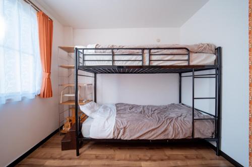 Un dormitorio con dos literas en una habitación. en Guesthouse & Kitchen Hace - Vacation STAY 68911v, en Iwaki