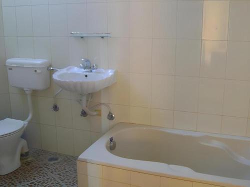 łazienka z wanną, umywalką i toaletą w obiekcie Mystique Highland Resort w mieście Astam