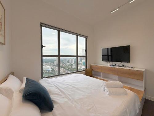 una camera da letto con un letto bianco e una grande finestra di The Sun Avenue Riverside Apartments in District 2 ad Ho Chi Minh