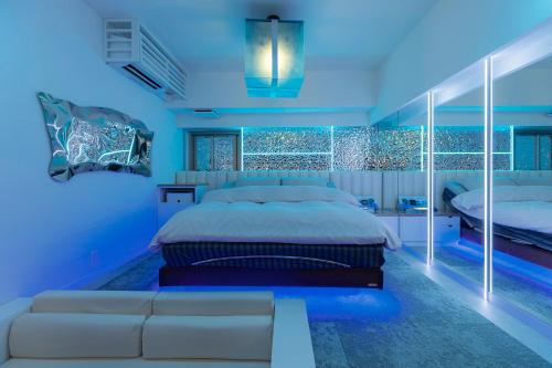 a blue bedroom with a bed and a couch at Design Hotel W Zip Club in Nagoya