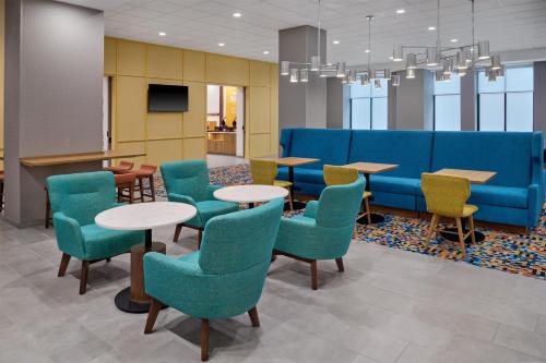 a waiting room with tables and chairs and a blue couch at Hampton Inn by Hilton Lincoln Downtown in Lincoln