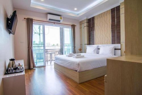 Un dormitorio con una cama grande y un balcón. en At Home at Udon, en Udon Thani