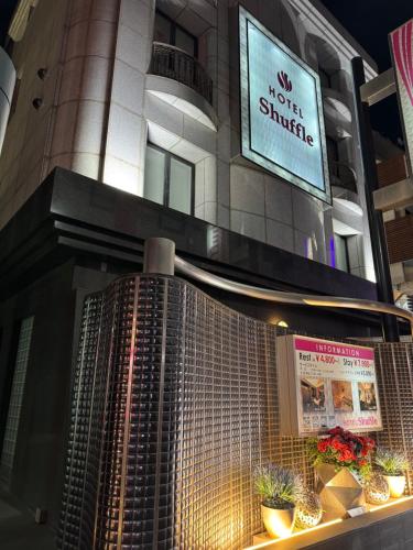 a building with a sign that reads no guest struggle at HOTEL Shuffle in Tokyo