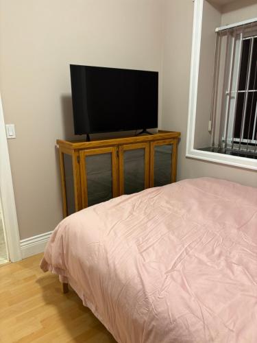a bedroom with a flat screen tv on a dresser at Vacation Home in Vancouver