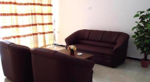 a living room with a couch and a coffee table at Hotel Glee in Challi