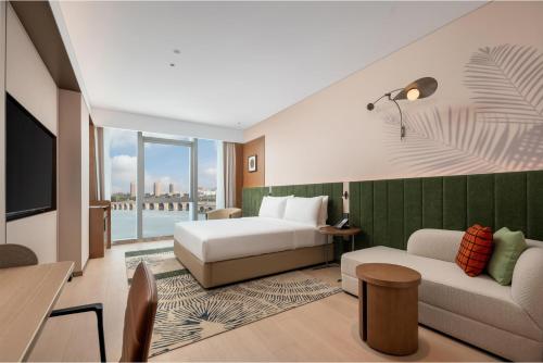 una camera d'albergo con un letto e un divano di Hilton Garden Inn Wuhu Economic Tech Zone a Wuhu