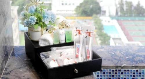 a black box filled with toothbrushes and a plant at Elysion Place Hotel Causeway Bay in Hong Kong