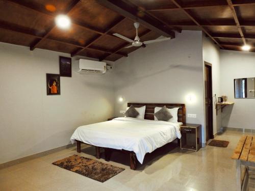 a bedroom with a large white bed in a room at Entire Farm house in Jim Corbett with staff and cook in Rāmnagar