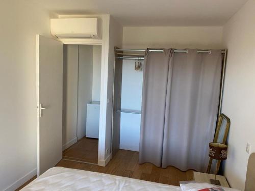 a bedroom with a bed and a shower curtain at Chambre Shelby vue mer avec kitchenette in Porto-Vecchio