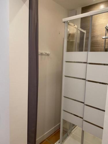 a glass closet with a ladder in a room at Chambre Shelby vue mer avec kitchenette in Porto-Vecchio
