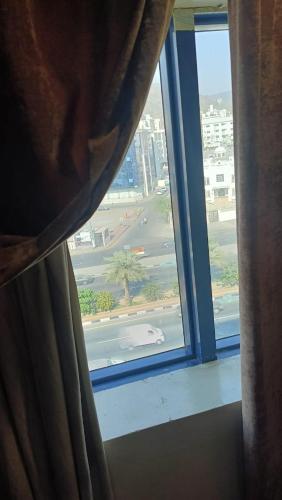 a person looking out of a window at a street at الرحابة المكية الفندقية in Al Masfalah