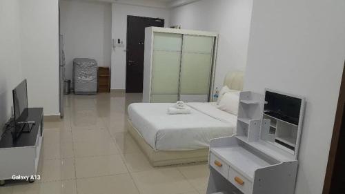 a bedroom with a bed with a mirror and a tv at Cyberjaya Studio Suite By NSB in Cyberjaya