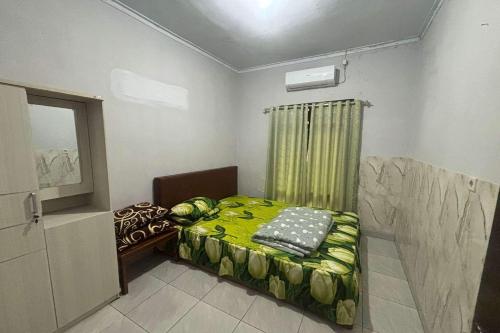 Un pat sau paturi într-o cameră la OYO 95050 Penginapan Sekarsari Syariah