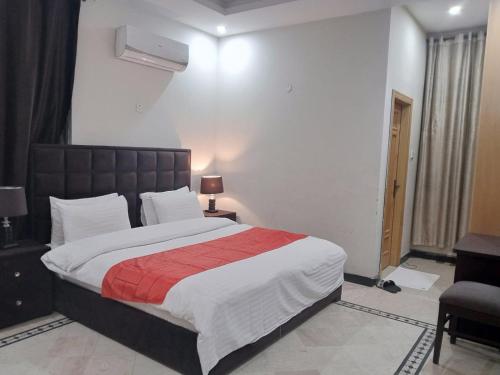 a bedroom with a large bed with a red blanket at Islamabad Pak Palace guest house in Islamabad