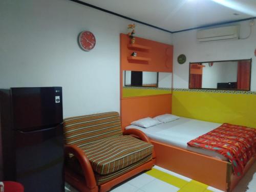 Un dormitorio pequeño con una cama y un refrigerador. en OYO 95039 Hotel Agung Permata Artha, en Bojongsalam