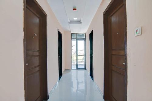 a hallway with two brown doors and white walls at OYO 95058 Agago Homestay Syariah in Kedungtengkong