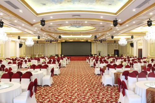 a large banquet hall with white tables and chairs at Hai Yen Luxury Hotel in Cẩm Phả