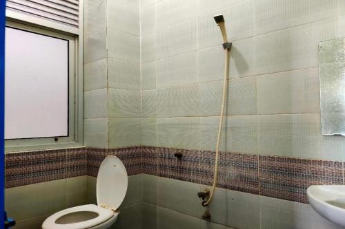 un baño con inodoro y lavabo en Hotel O Pondok Baruga 777 Near Sarewo Musik Studio Kendari, en Puunggolaka