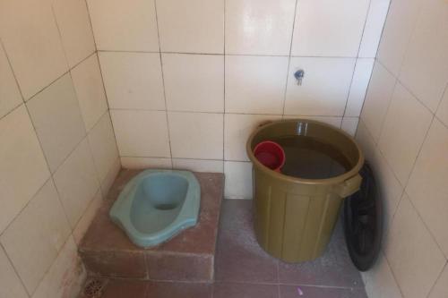 a bathroom with a toilet and a trash can at Hotel O Guest House Wijaya Syariah Near alun alun kota purwokerto in Purwokerto