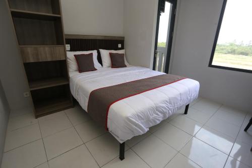 Un dormitorio con una cama grande en una habitación. en Capital O 95049 Aurora Rooms @ Riverdale, en Tanahbaru